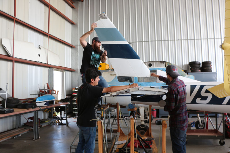 three students with airplane