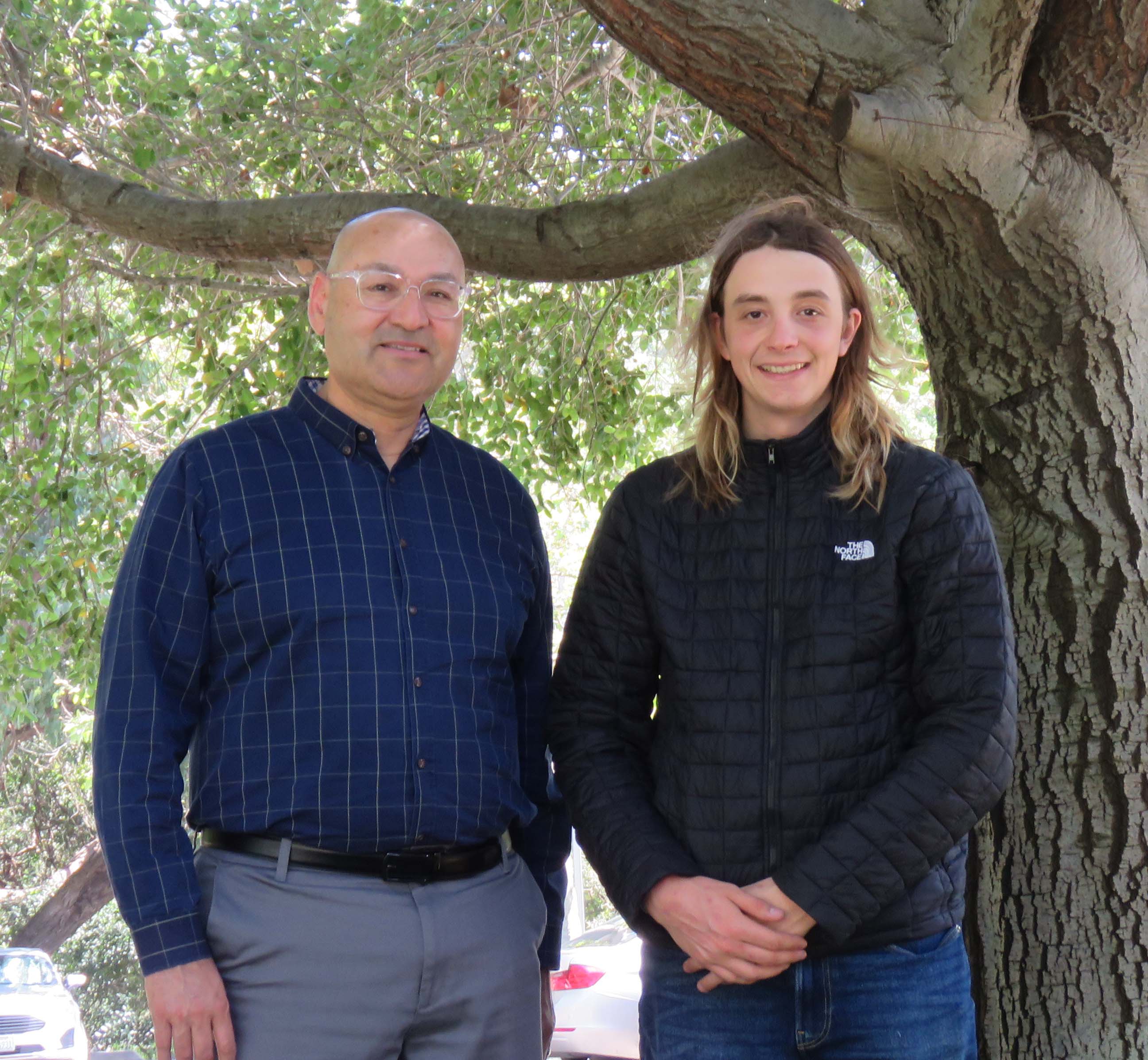 Dr. Pedro Avila and Cipriano Echezarreta standing in front of a tree