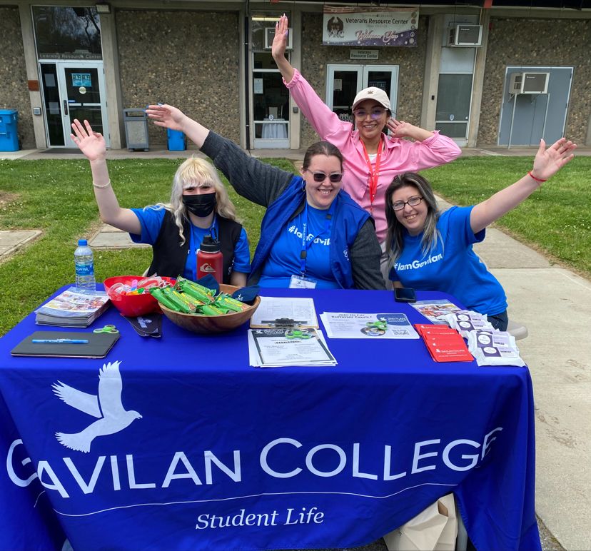 Career Fair tabling with three students and the Career and Academic Pathway Specialist