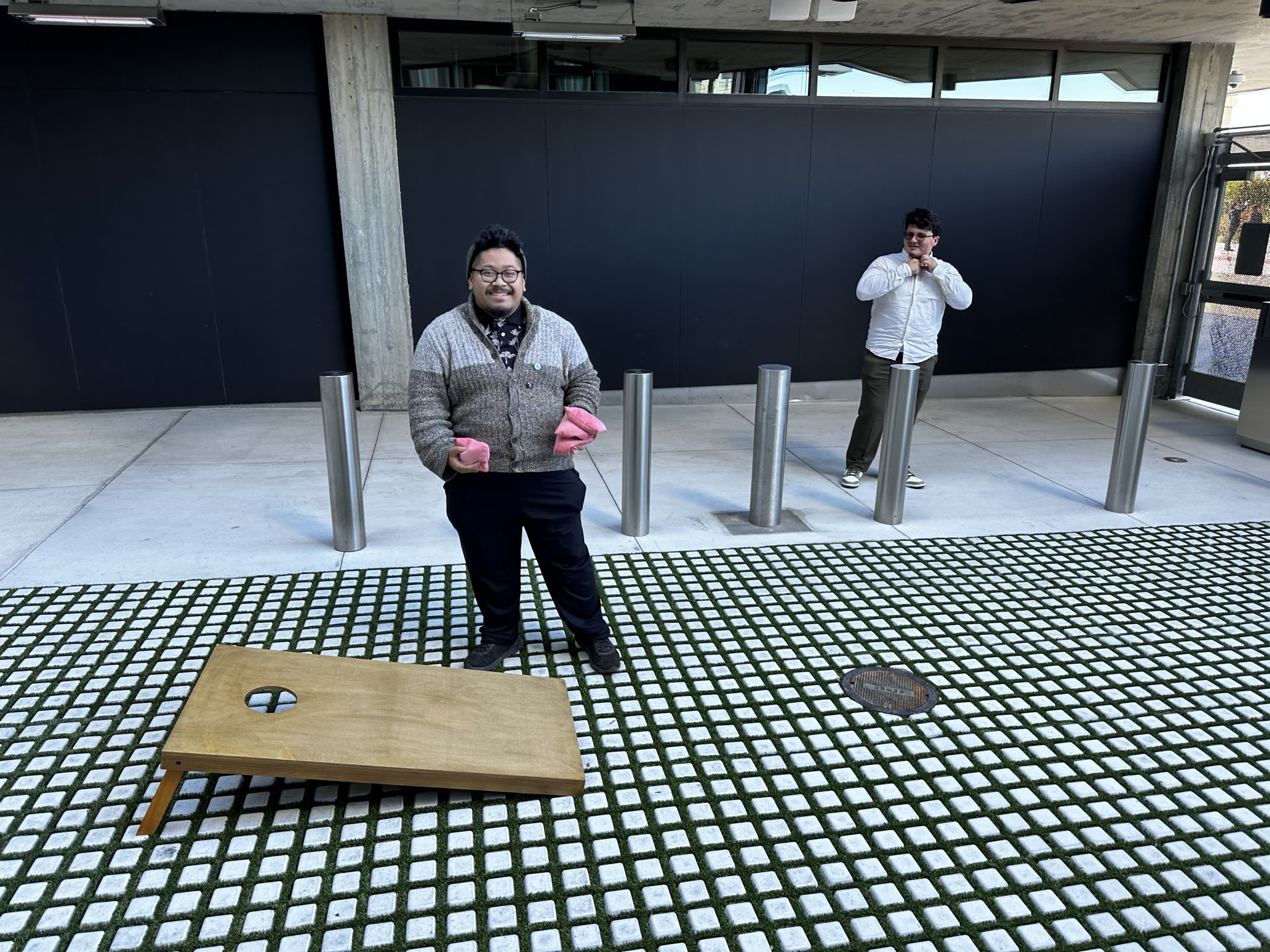 An image of two students chilling in front of a building.