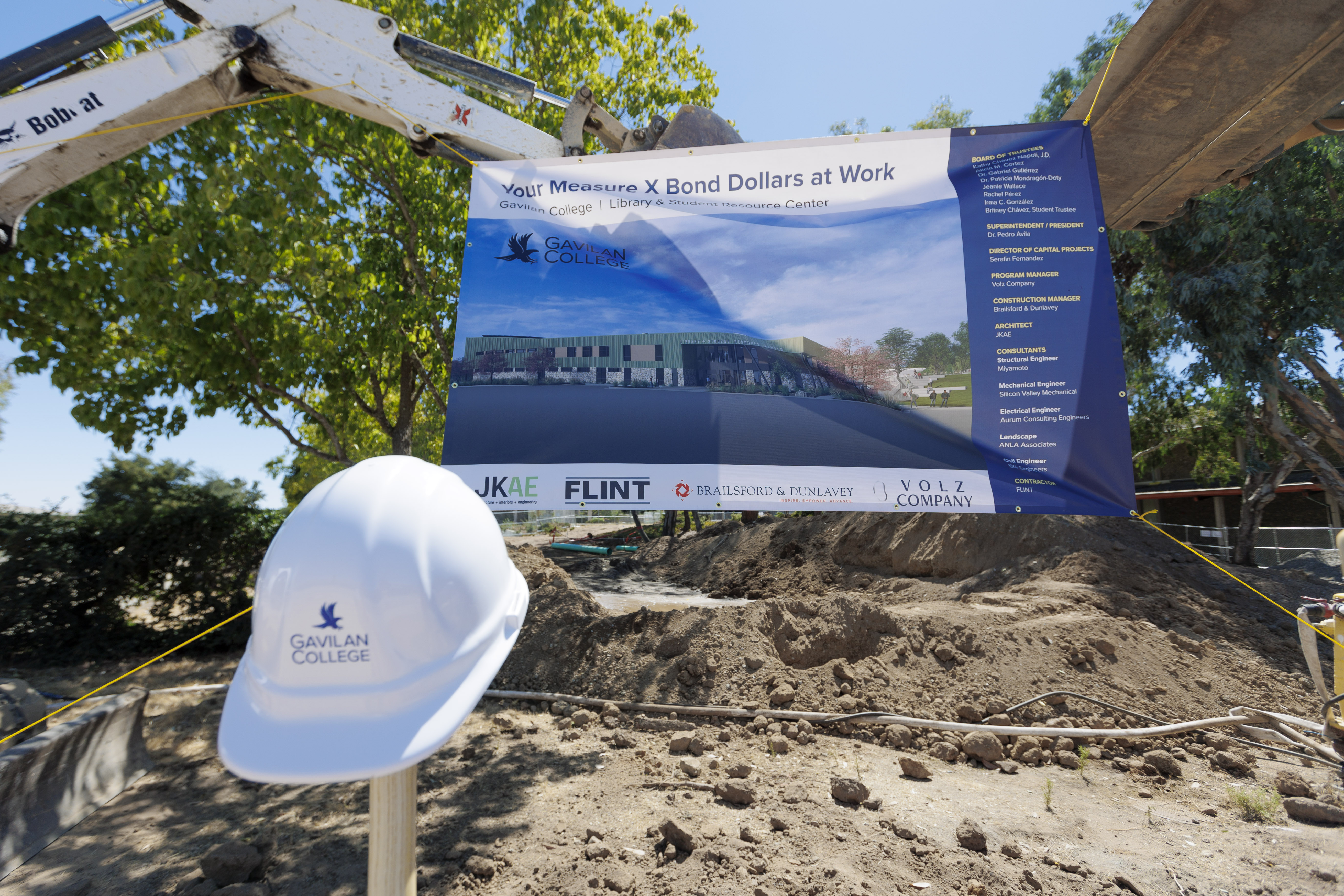 Banner with image of new building, hardhat with Gavilan College hawk logo, and building equipment.